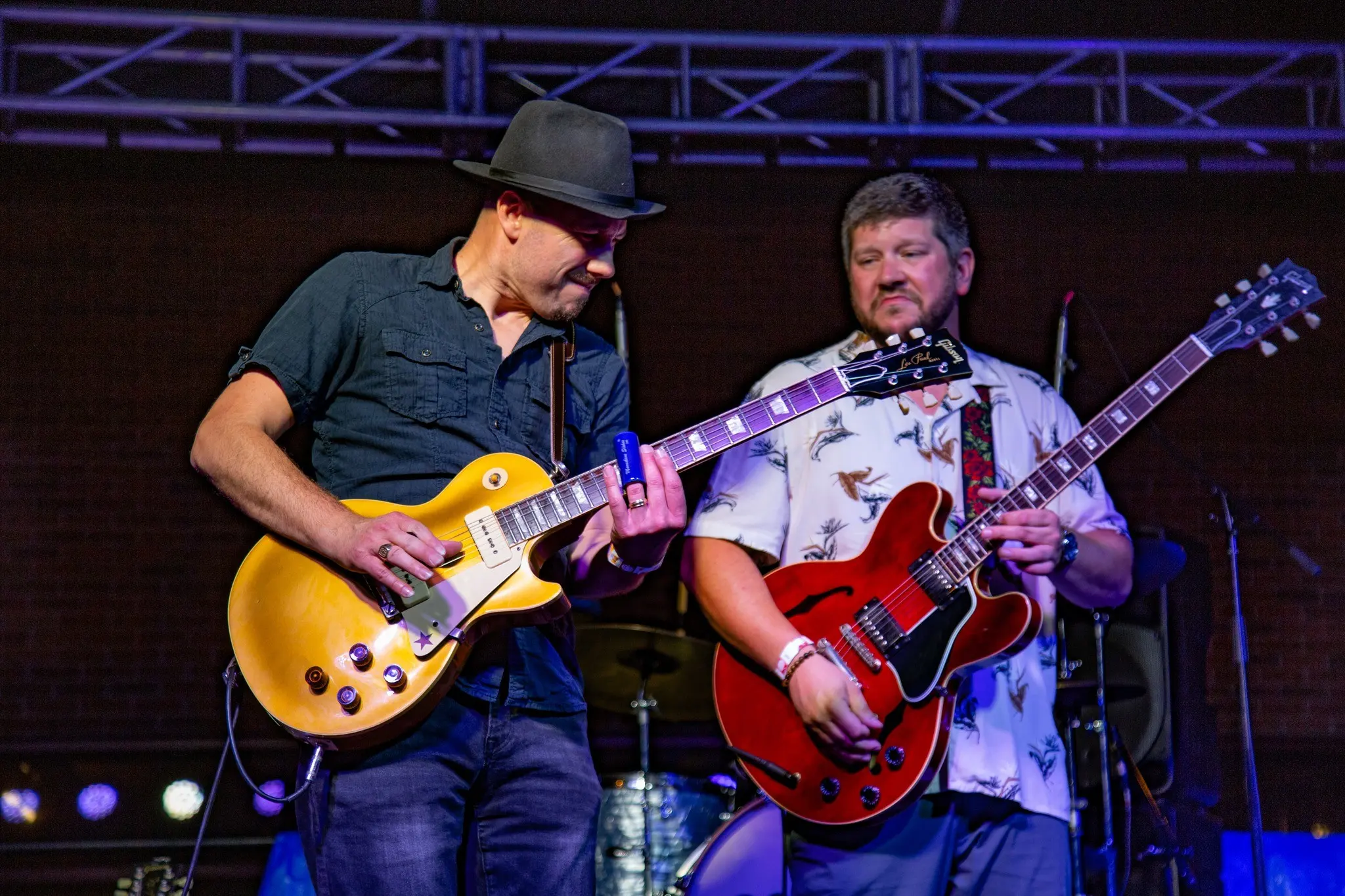 Two guitarists playing side by side onstage at night